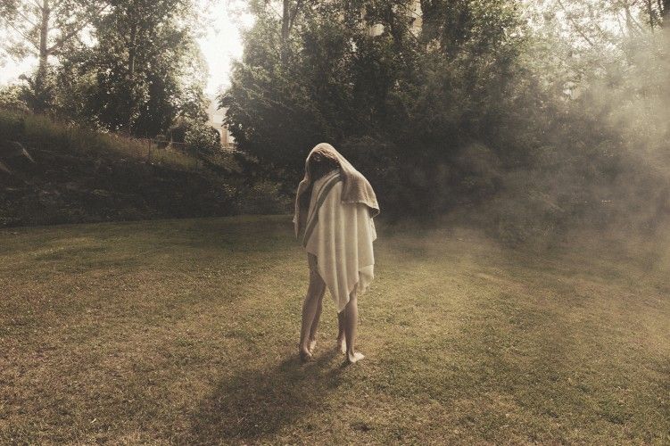 A figure draped in cloth on a misty lawn, from This Must Be The Place